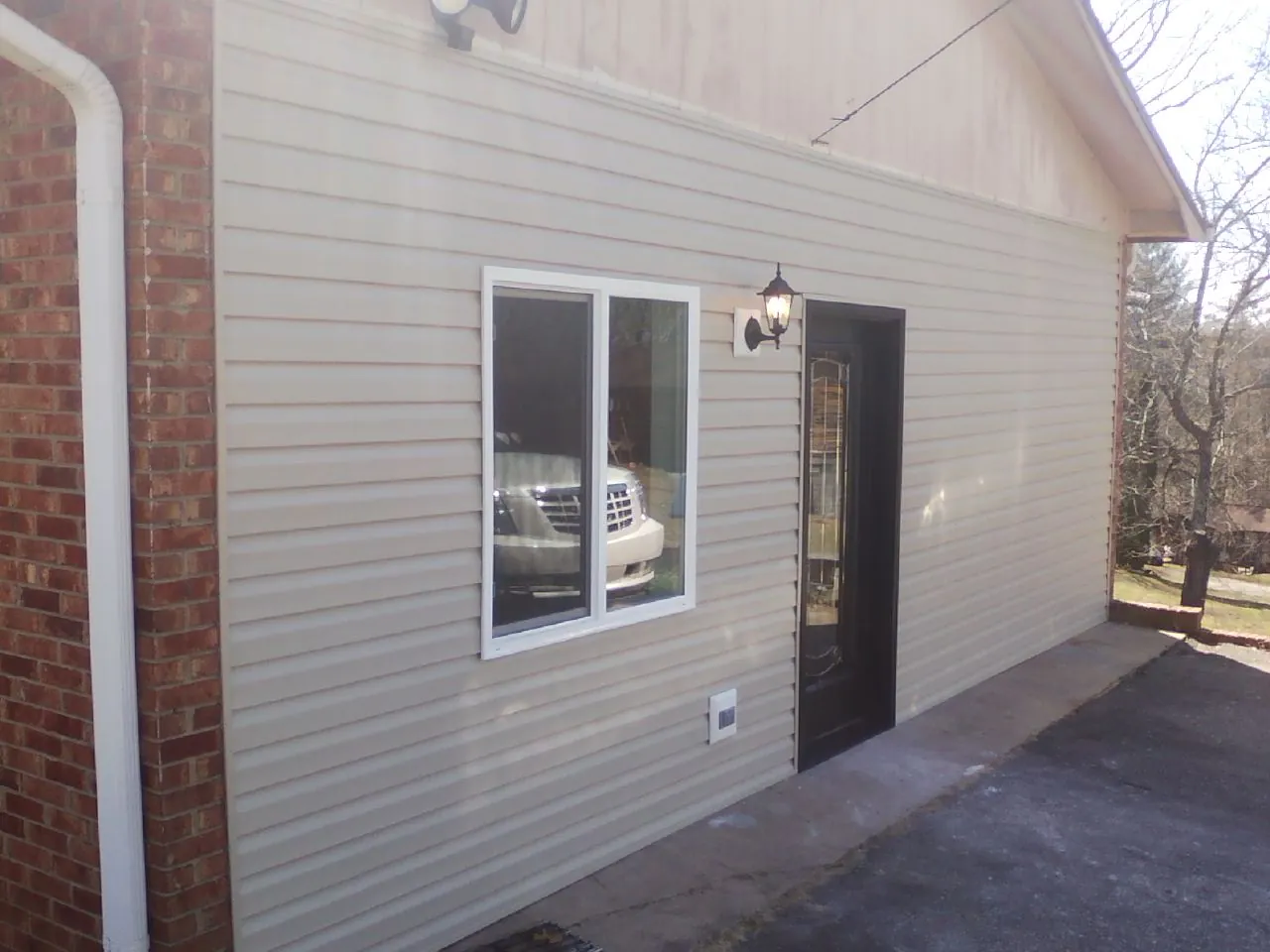 New vinyl siding and entry door on a room addition in South Sutton