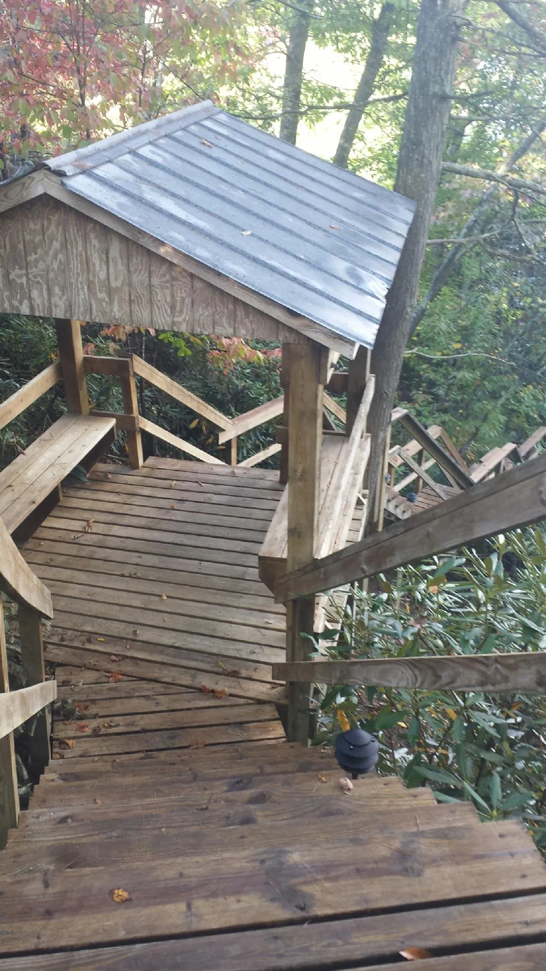 Metal roofed shelter over wooden steps on a wooded walkway — Skylight Repair & Installation work by our crew in South Sutton